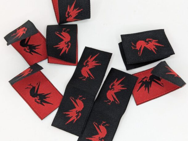 Custom woven label with detailed design and text, perfect for branding apparel and accessories